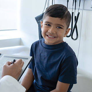 Image of a smiling your child being examined by a doctor