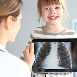 Radiologist showing an young girl an x-ray image of her lungs