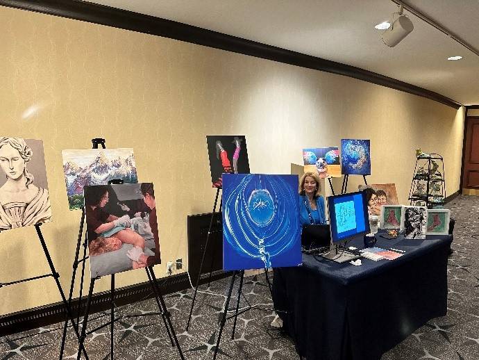 A women displays her artwork at the ACR 2023 Annual Meeting