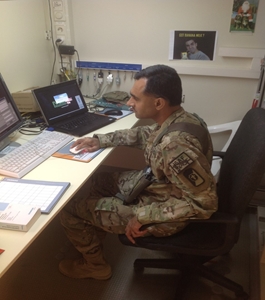 Photo of Mohammad Naeem, MD, FACR, operating the CT scanner by himself at his deployment site in the absence of a CT technologist.