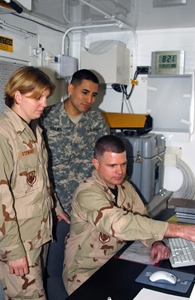 Photograph of soldiers reviewing an X-ray at the Air Force Theater Hospital at Balad Air Base, Iraq.