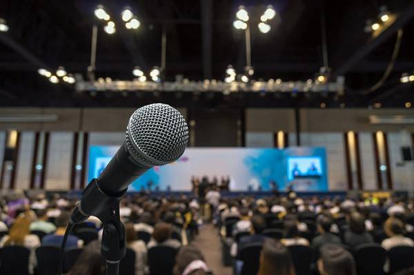 Microphone with Abstract blurred photo of conference hall or meeting room with attendee background, business and education concept