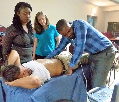 Melissa P. Culp, RT(R)(MR) & UNC Radiology alumni Ryan Embertson, MD with two Malawian medical officers teaching ultrasound scanning techniques in Malawi, 2017.