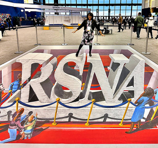 Surbhi Raichandani, MD, poses on RSNA chalk art during the RSNA 2022 Annual Meeting