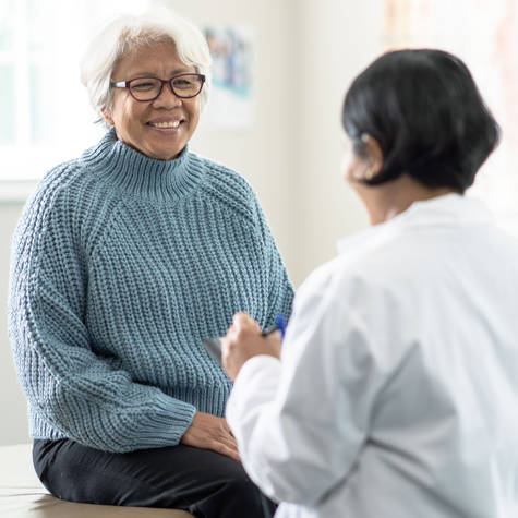 Doctor counseling smiling middle-aged female patient